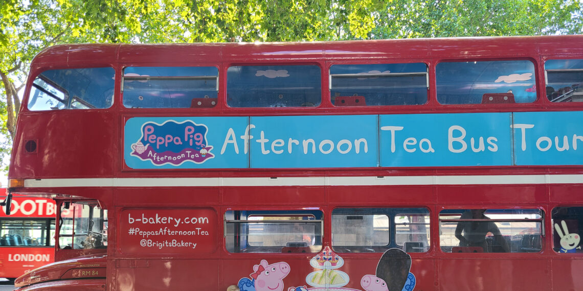 Red Double Decker Bus with "Afternoon Tea Bus Tour" Banner and Peppa Pig Logo